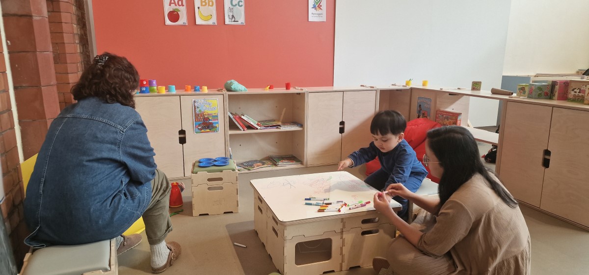 A picture of a child and two adults playing together within the breakout space package, designed by Pentagon Play
