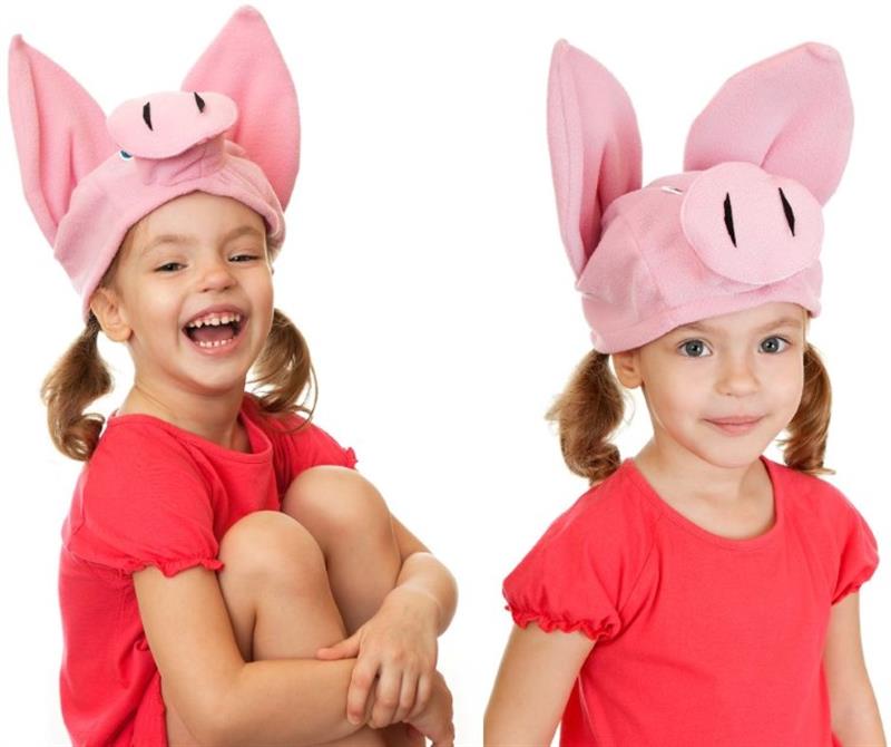 a little girl sits with a pig mask