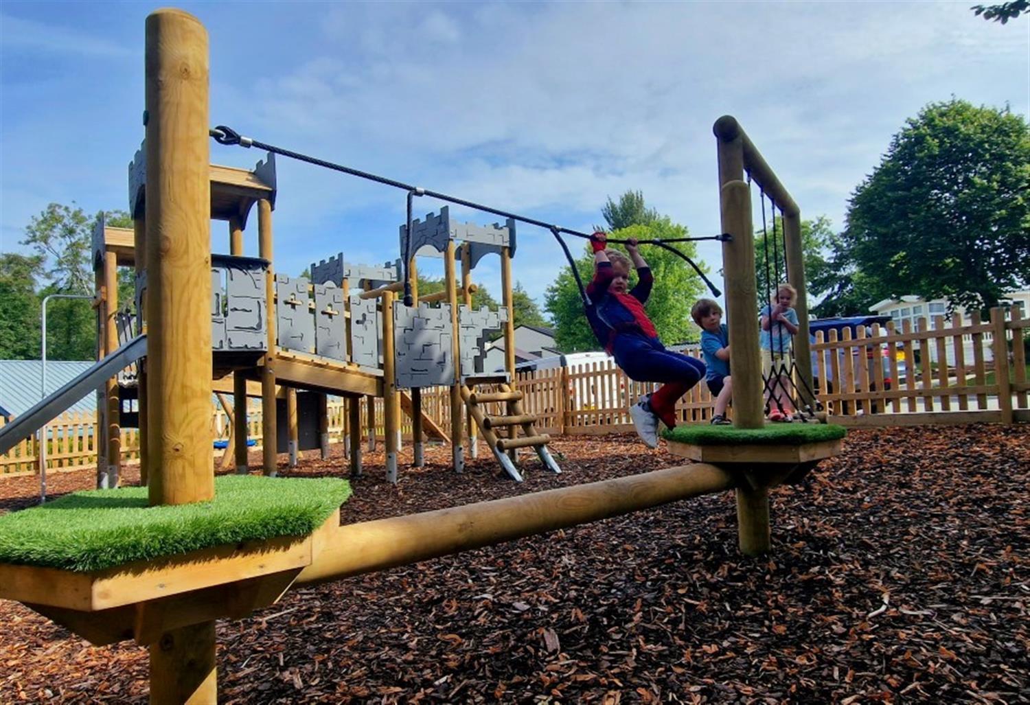 A picture of a trim trail with children playing on the equipment that Pentagon Play installed at Bryntag holiday park 