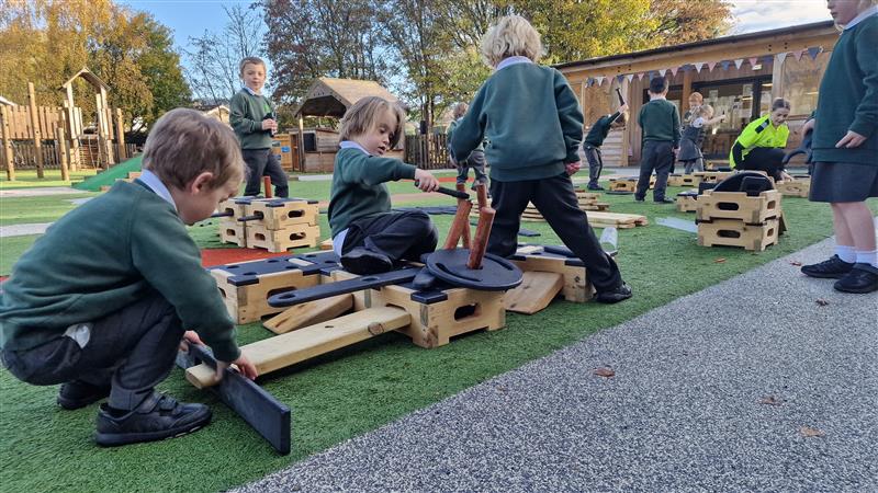 A class of children are playing with the Play Builder Engineer Set with Role Play Additions. A lot of the children are creating new structures whilst the teachers are roaming around and helping kids with their projects.
