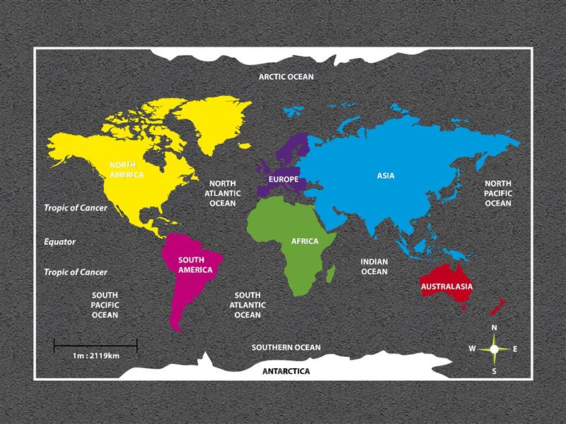 A playground graphic that displays the world map and highlights all of the continents. yellow marks North America, pink marks South America, purple marks Europe, green marks Africa, blue marks Asia, red marks Australasia and white marks Antarctica. The oceans have names written in their areas and a small compass can be seen in the bottom right.