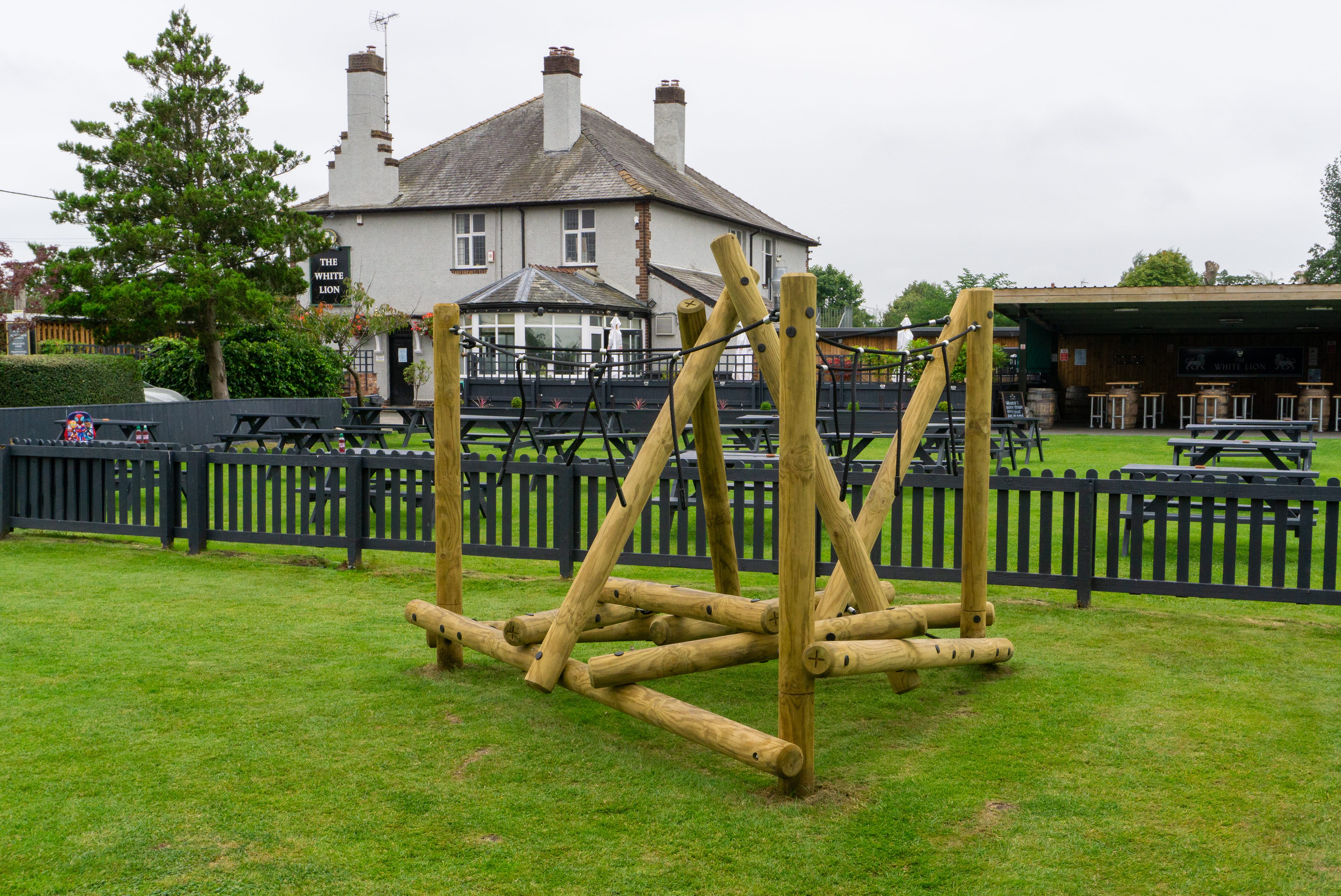 A photo showing the outdoor beer garden behind The White Lion. A Mam Tor Mountain Climber can be seen on the grass.