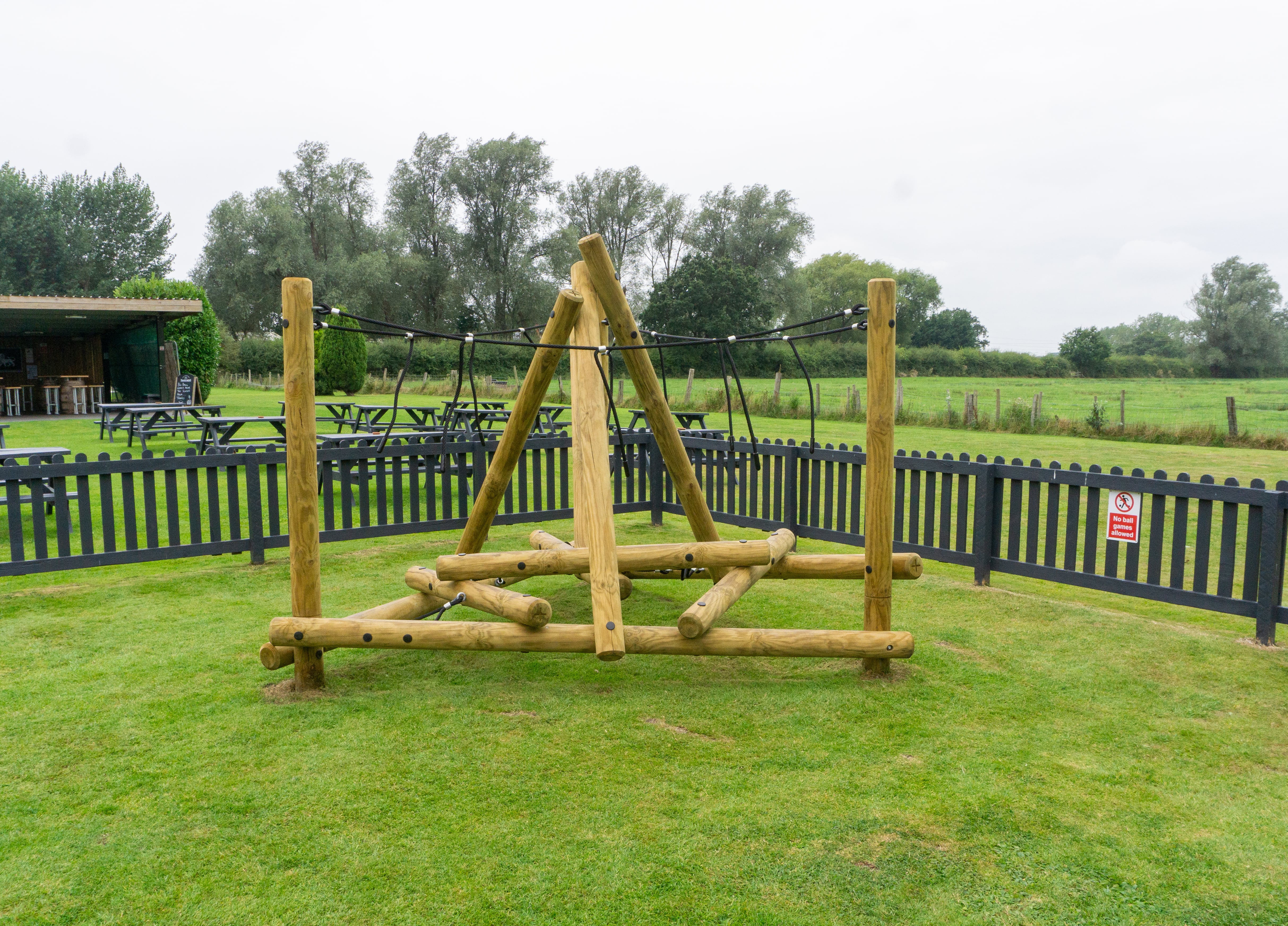 The Mam Tor Mountain Climber that has been installed on grass. The climbing frame is empty and stands by itself, surrounded by nature.