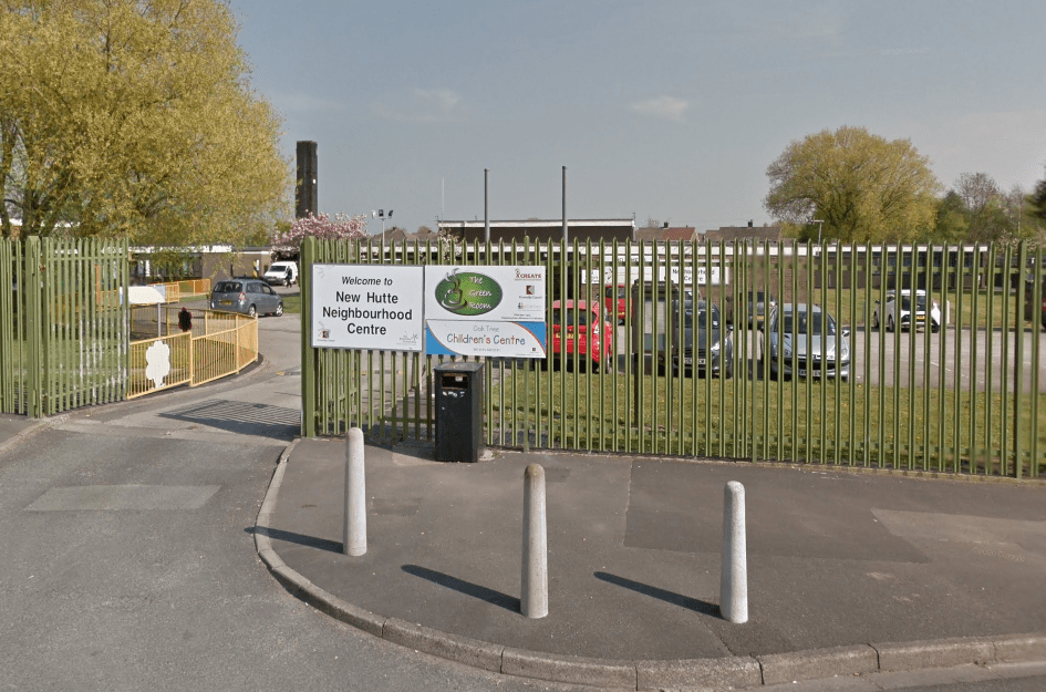 Outside of the New Hutte Neighbourhood Centre, showing the car park and the signs to the centre and nursery