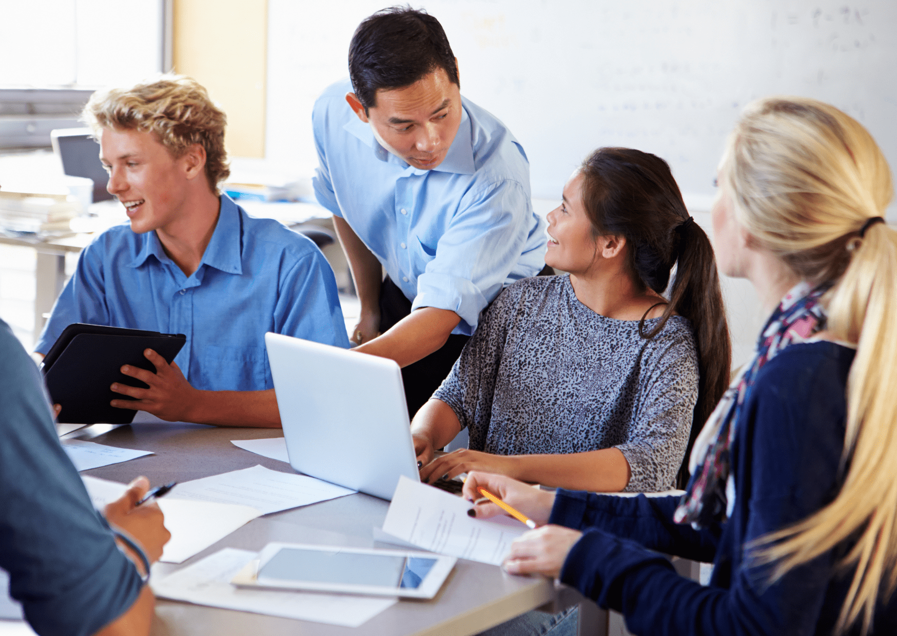 A government worker is helping stakeholders to deliver feedback surrounding the Ofsted inspections by giving directions on a laptop.