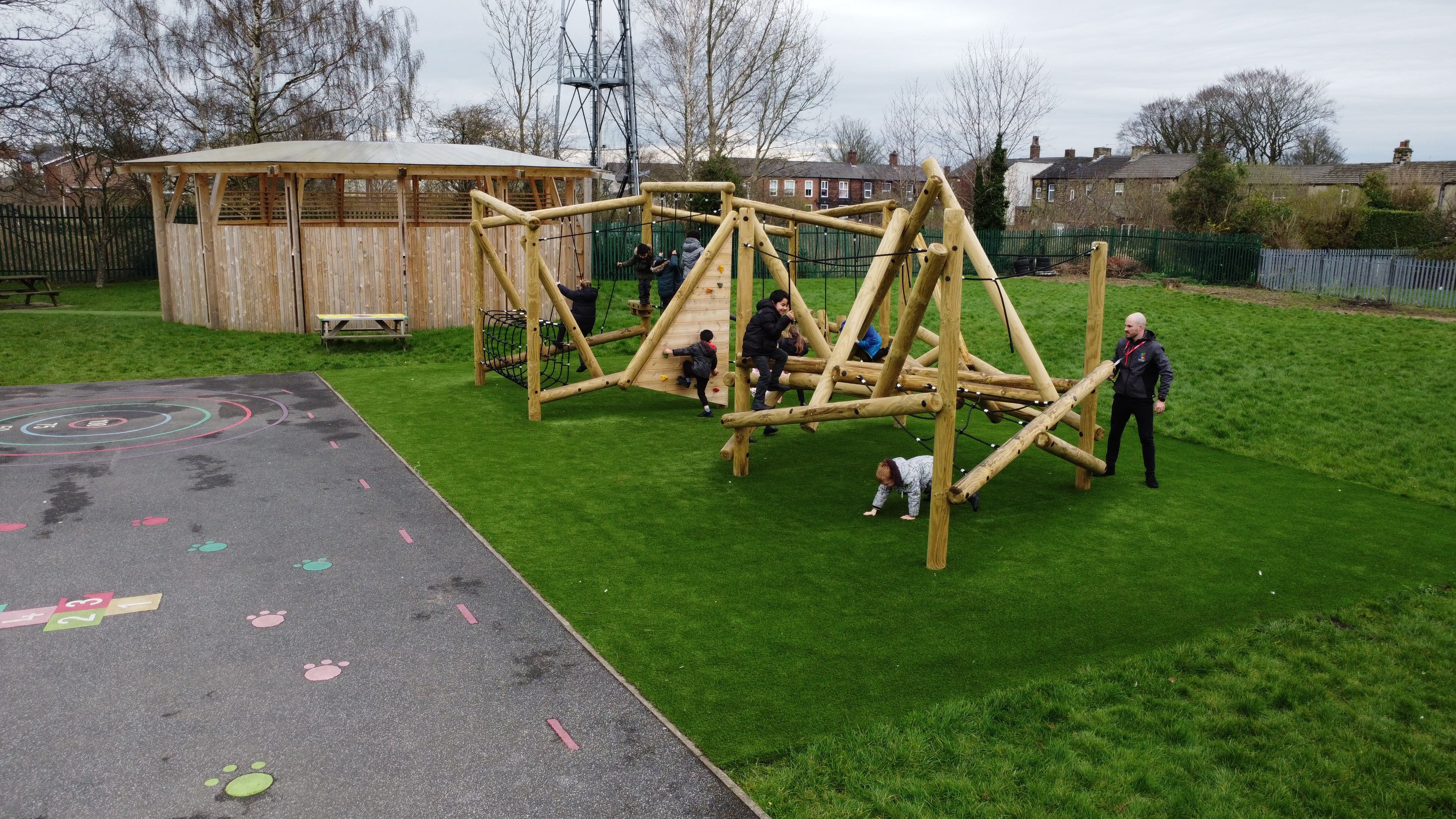 Another angle showcasing the big climbing frame and trim trail, both of which have been installed next to each other. Both pieces have been installed on artificial grass.