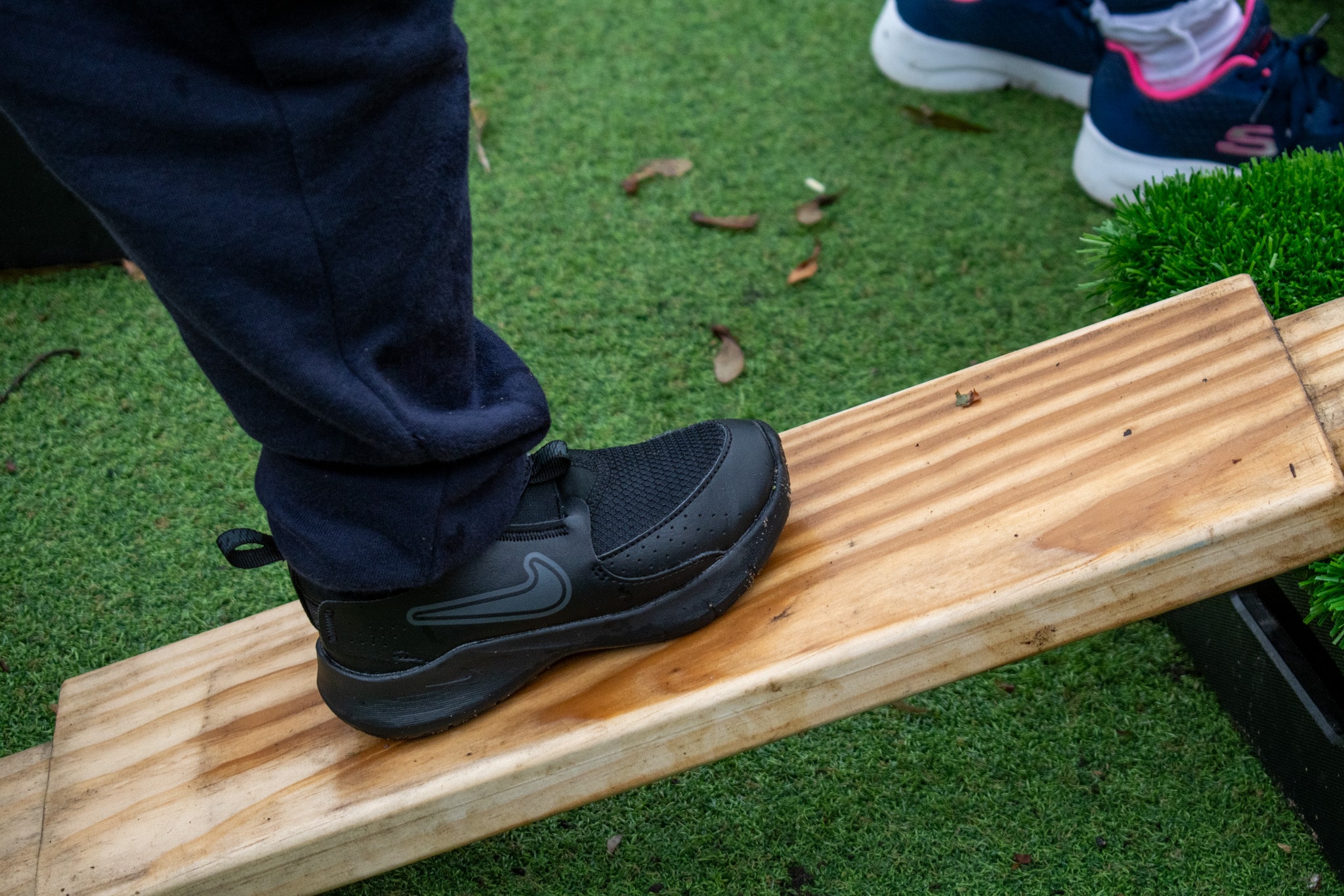 A close up showing the graining of a wooden plank that is included in the Play Builder set. The plank is made out of Accoya and has a child stood on the plank.