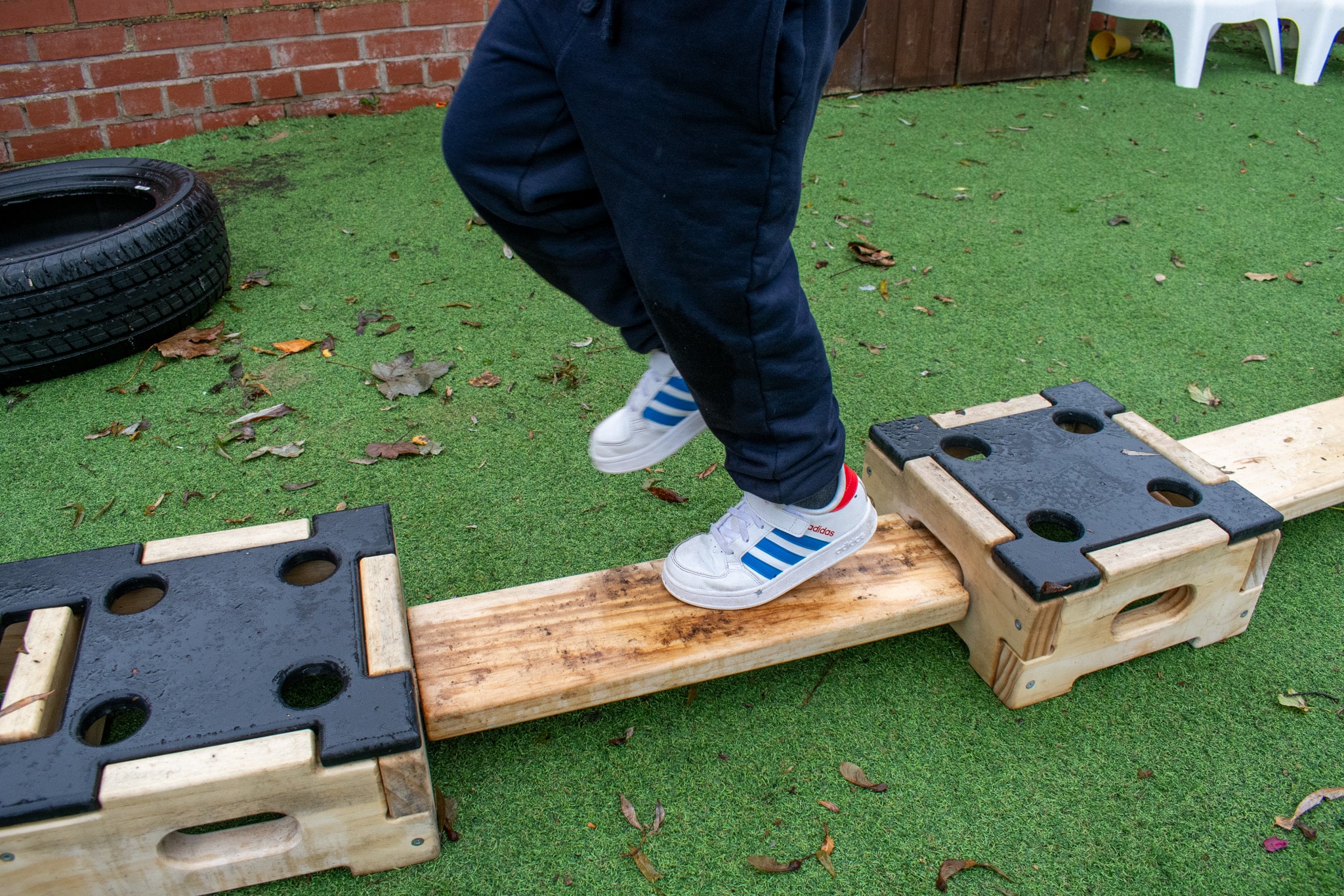 A close up showcasing a child running on an Accoya plank. The plank is wet and has a bit of mud on it but shows no signs of damage.