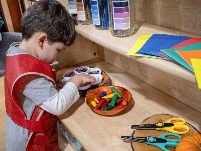 A little boy is looking through a variety of crafting materials that are stored on a Millhouse Welsh Dresser.