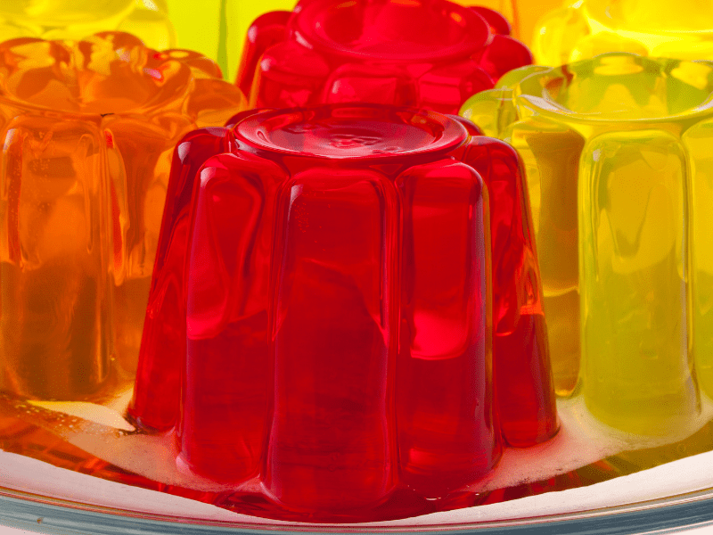 A close up of orange, lemon and strawberry jelly blobs.