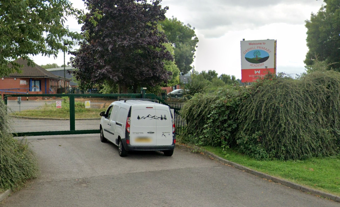 The Oakhill Primary Academy school building, with a green gate closing access to the dive