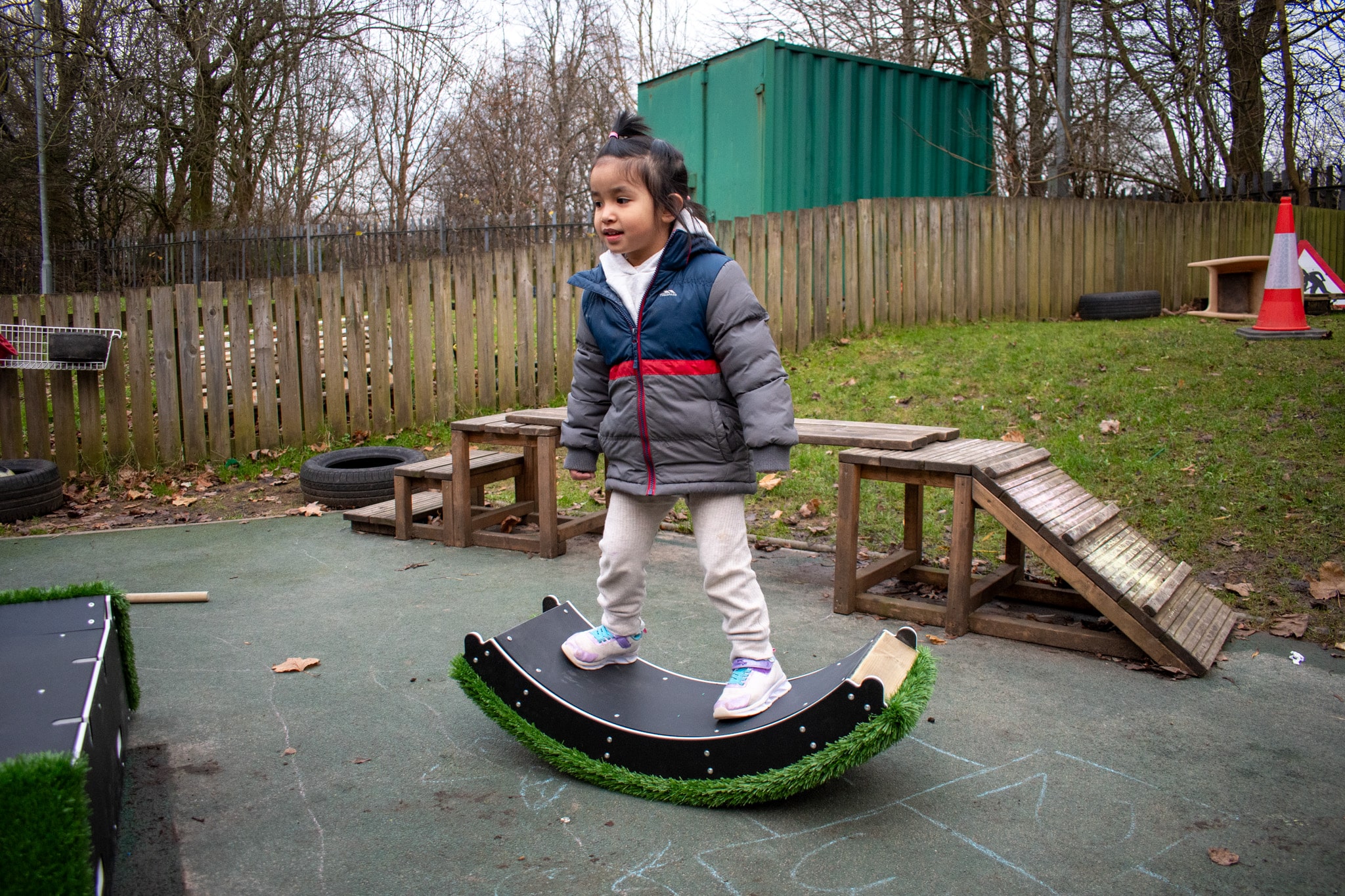 A child is stood on the rocker block from the Rockies and is rocking from side to side.