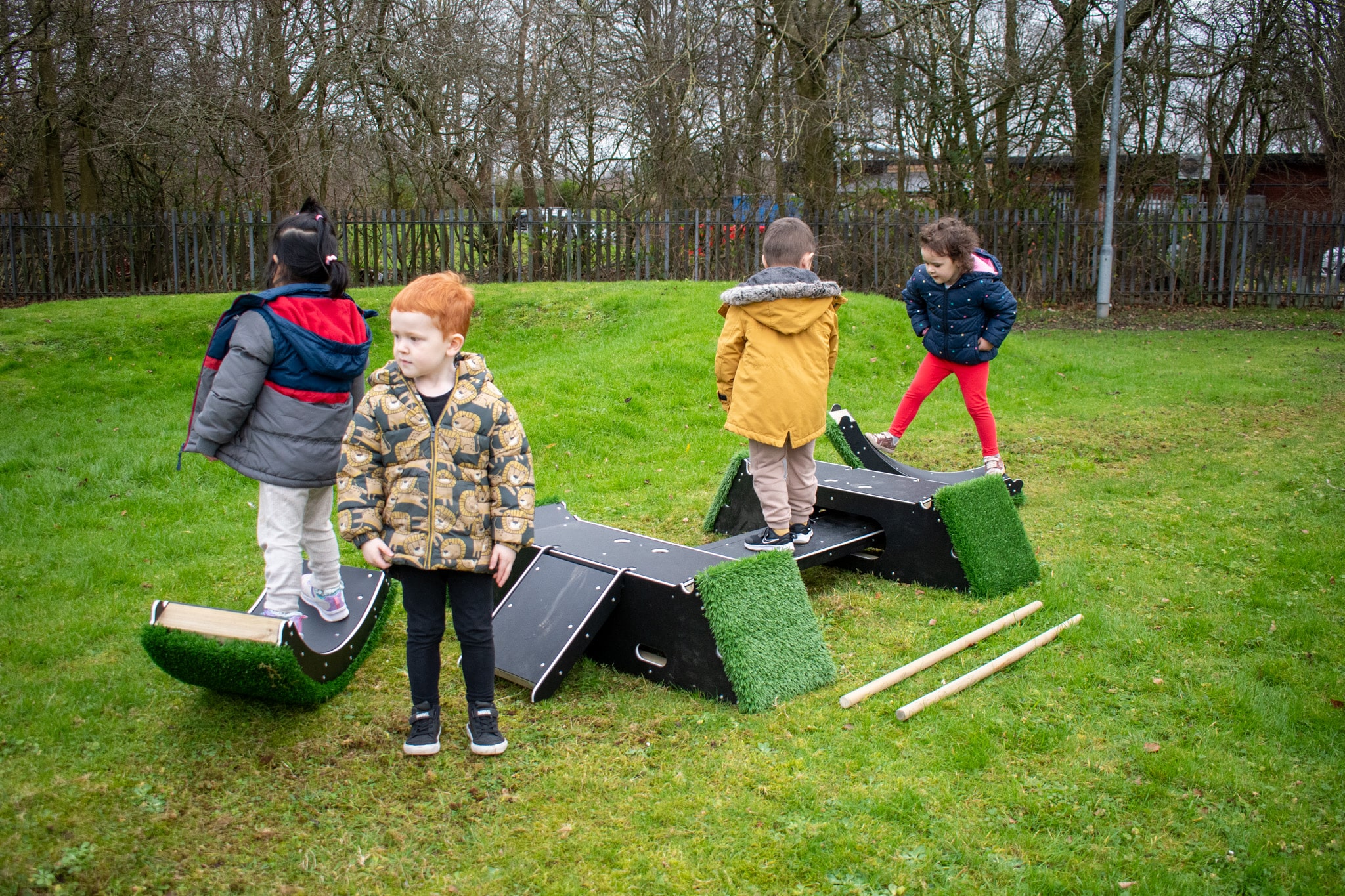 A group of children have took apart the Rockies and are exploring the various pieces of equipment separately. 