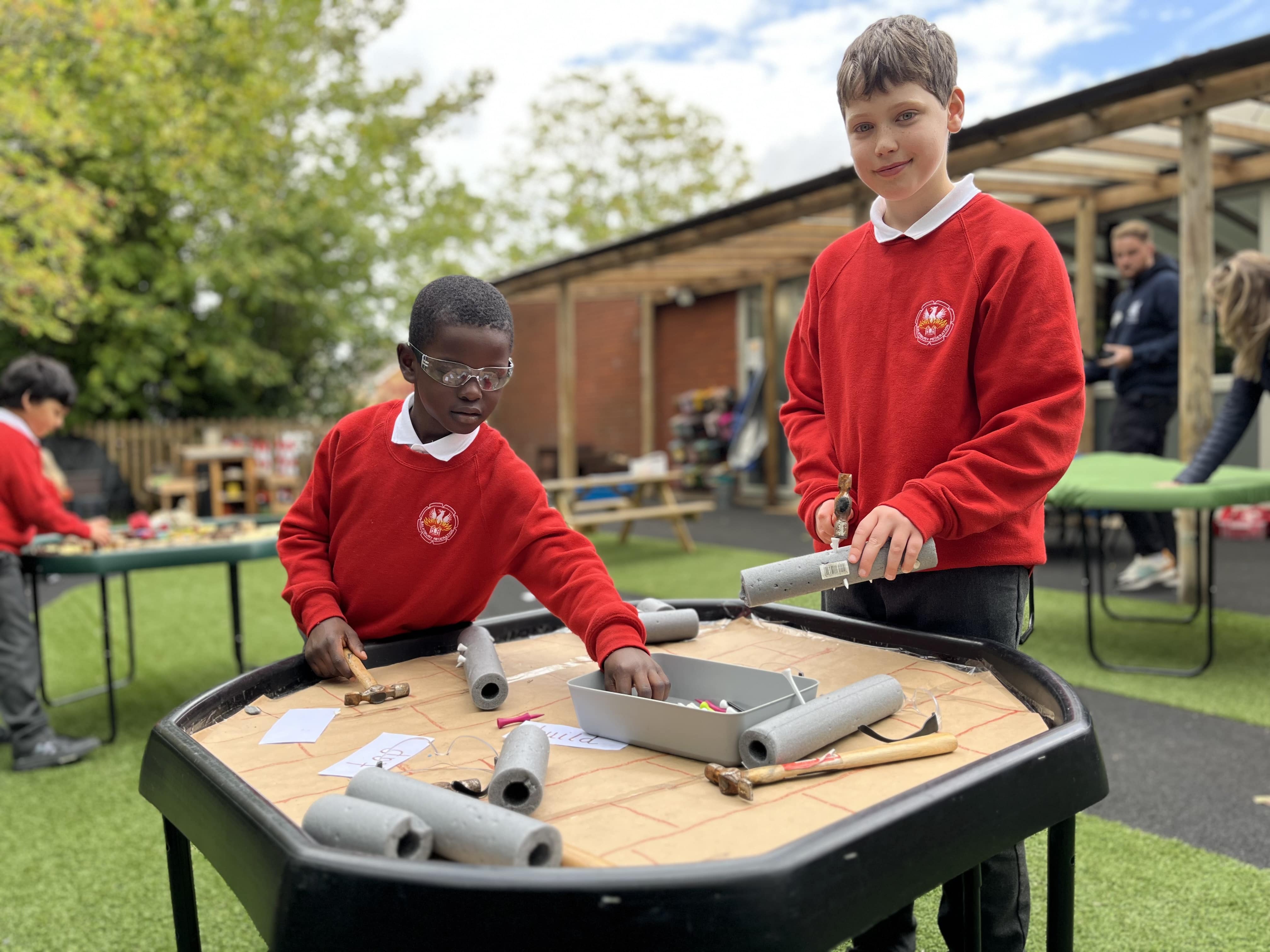 Two children are interacting with a piece of play equipment.