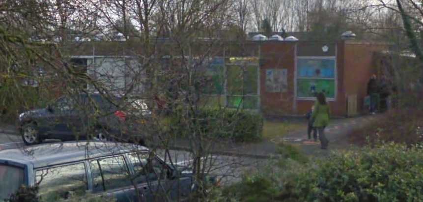 The building of a school with people walking into it.