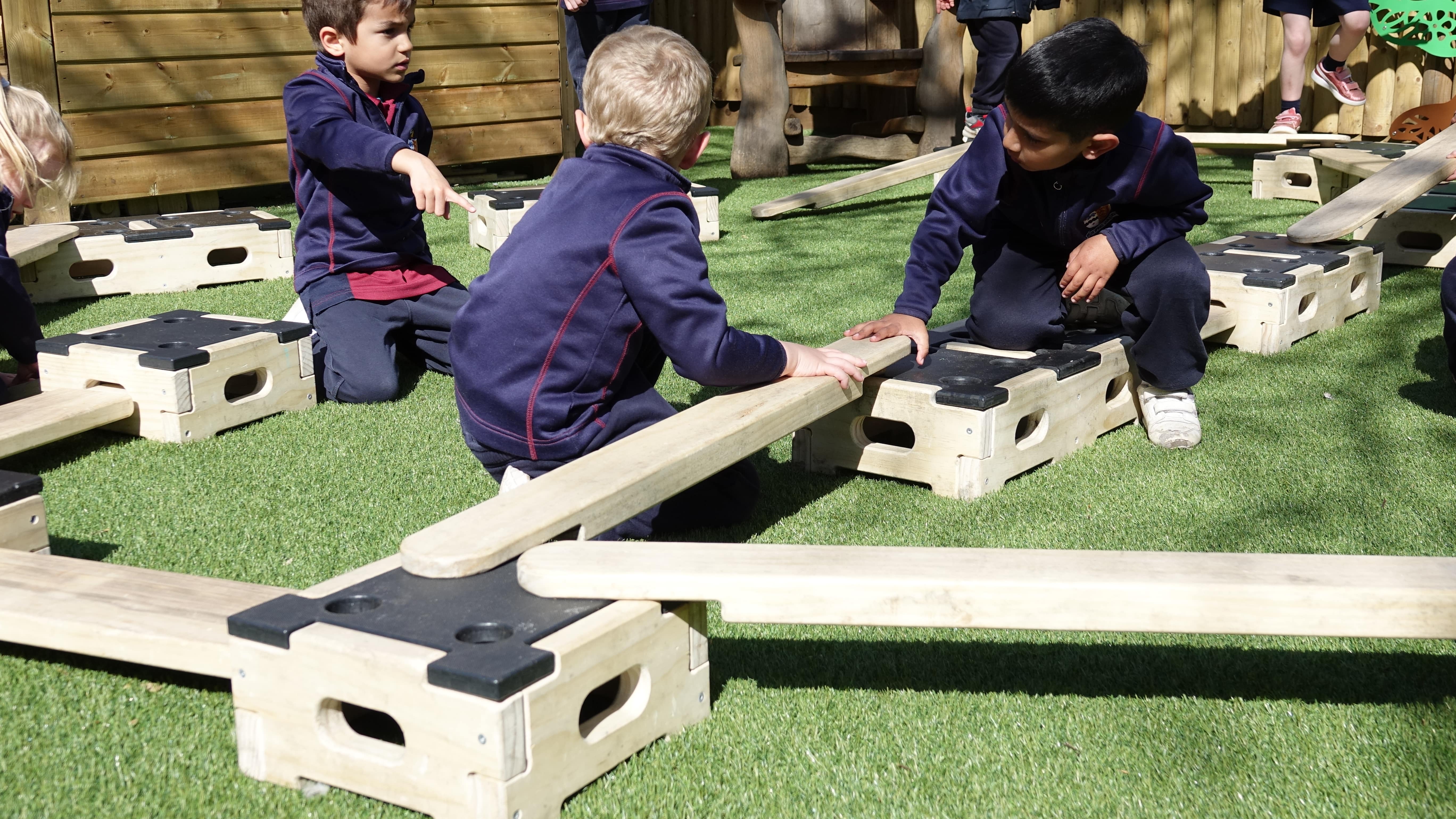 A group of children are building a circuit from the play builder set, together.