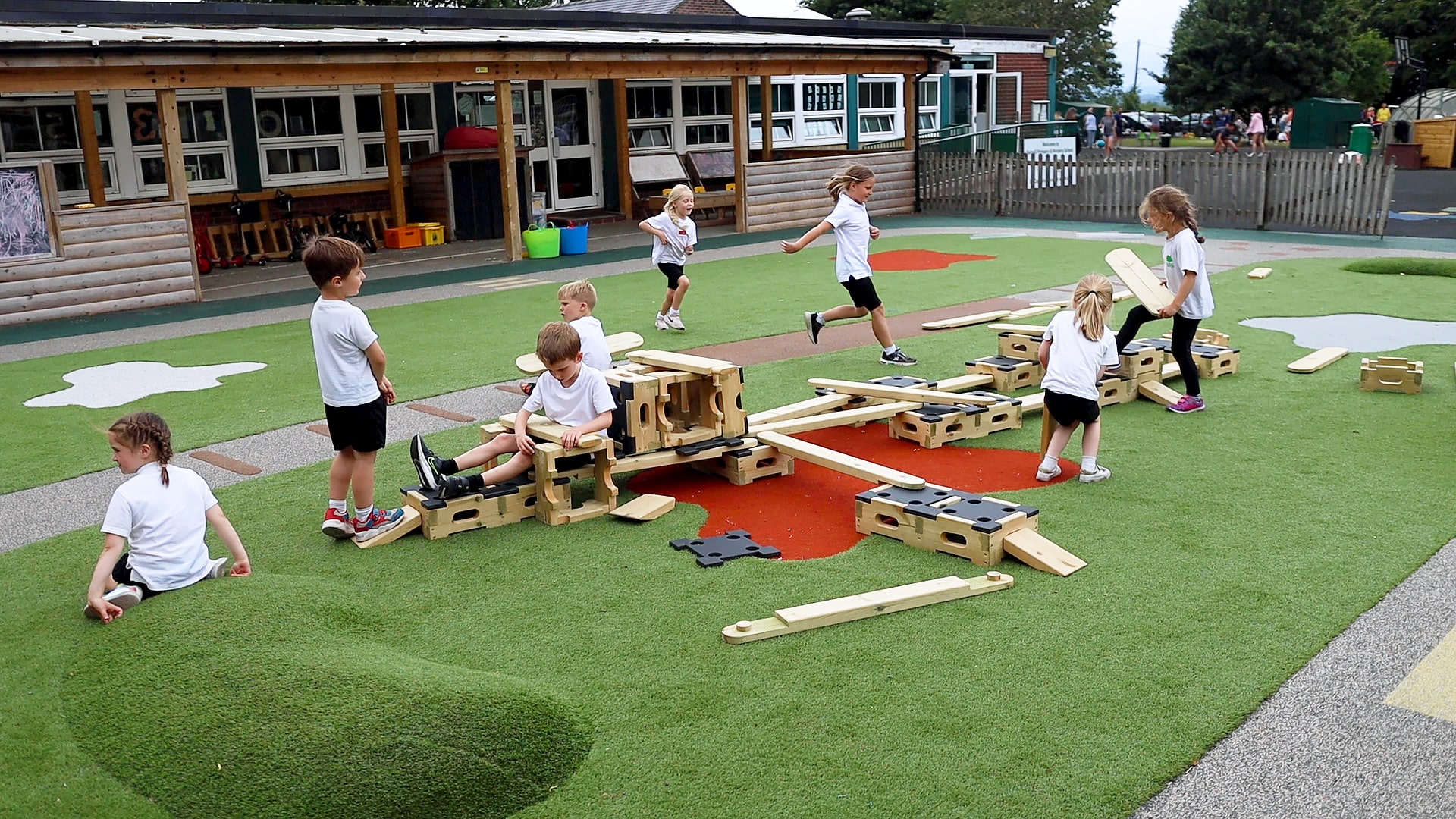 Children are playing on the Play Builder set, with some creating new parts to the pre-existing circuit that has been established.