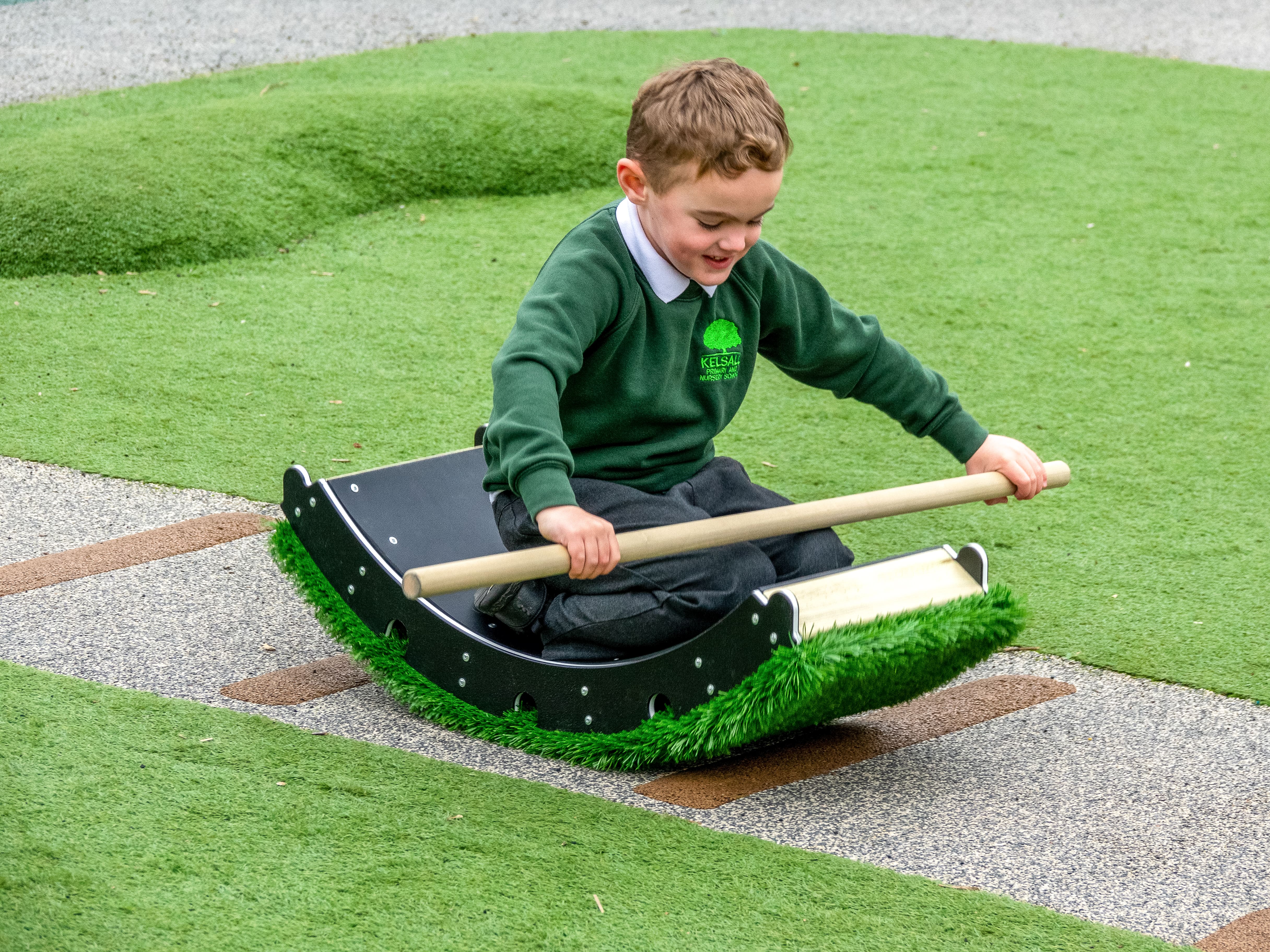 A little boy is kneeling on a Rocker block, which comes from the Rockies set. The boy is pretending to sail a boat.