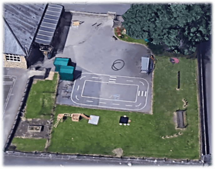 A tarmac playground with faded thermoplastic playground markings, with hardly any playground equipment.