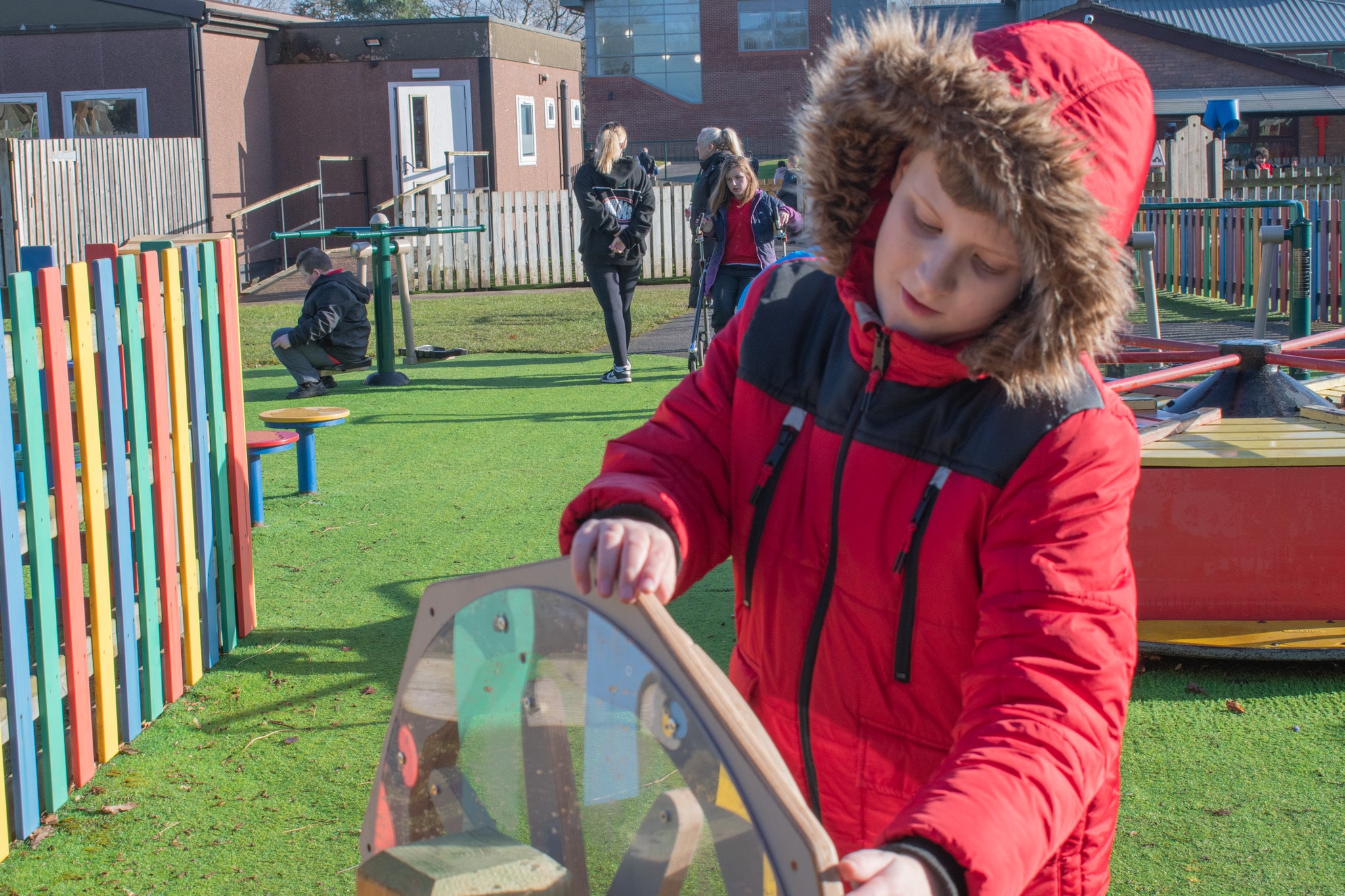 A little boy is spinning the Sound Sensory Spinner and is intrigued by the noise it's producing.