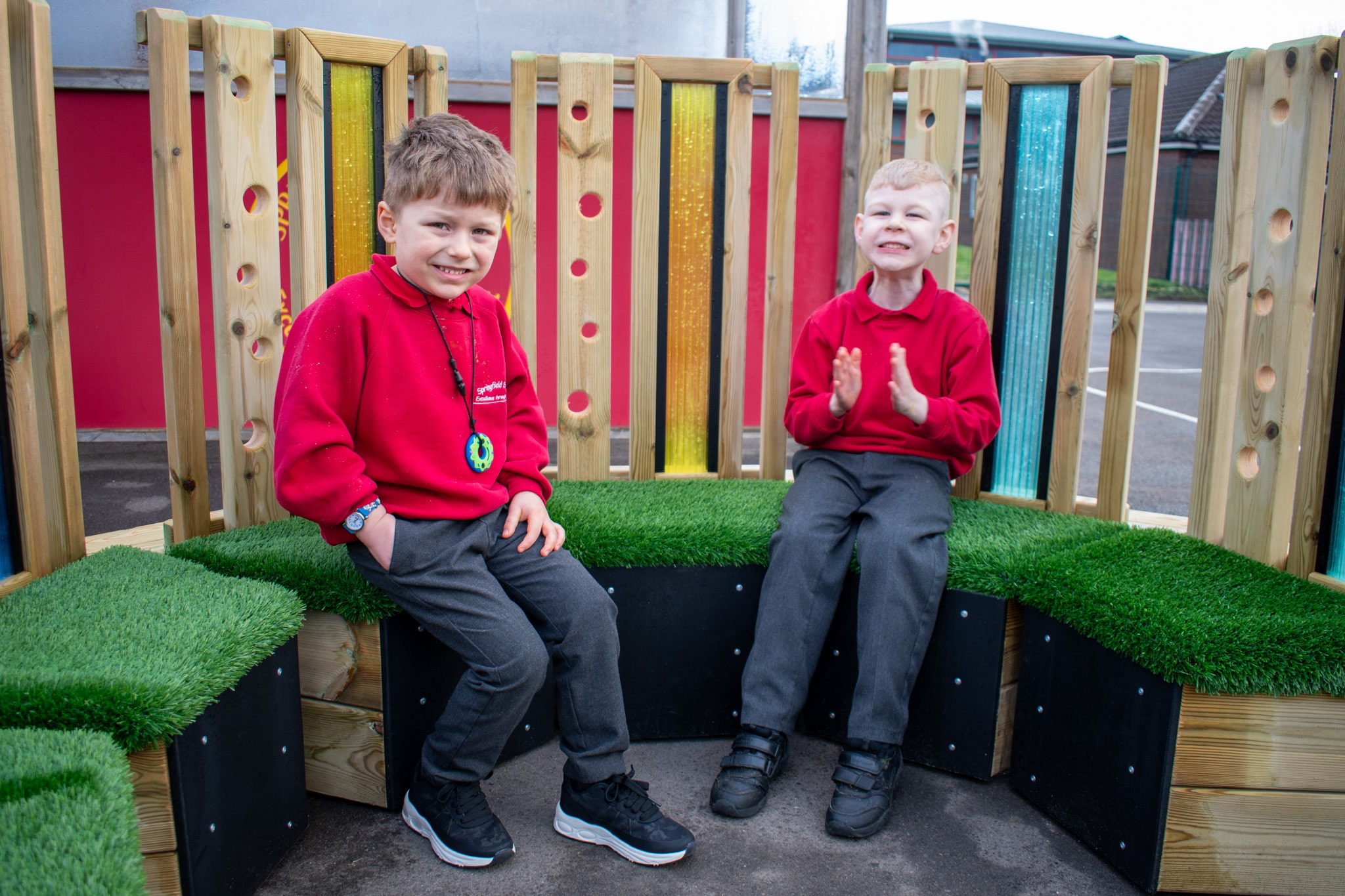 Two little boys are sat on the Sensory Seating Circle and are clapping towards the camera.