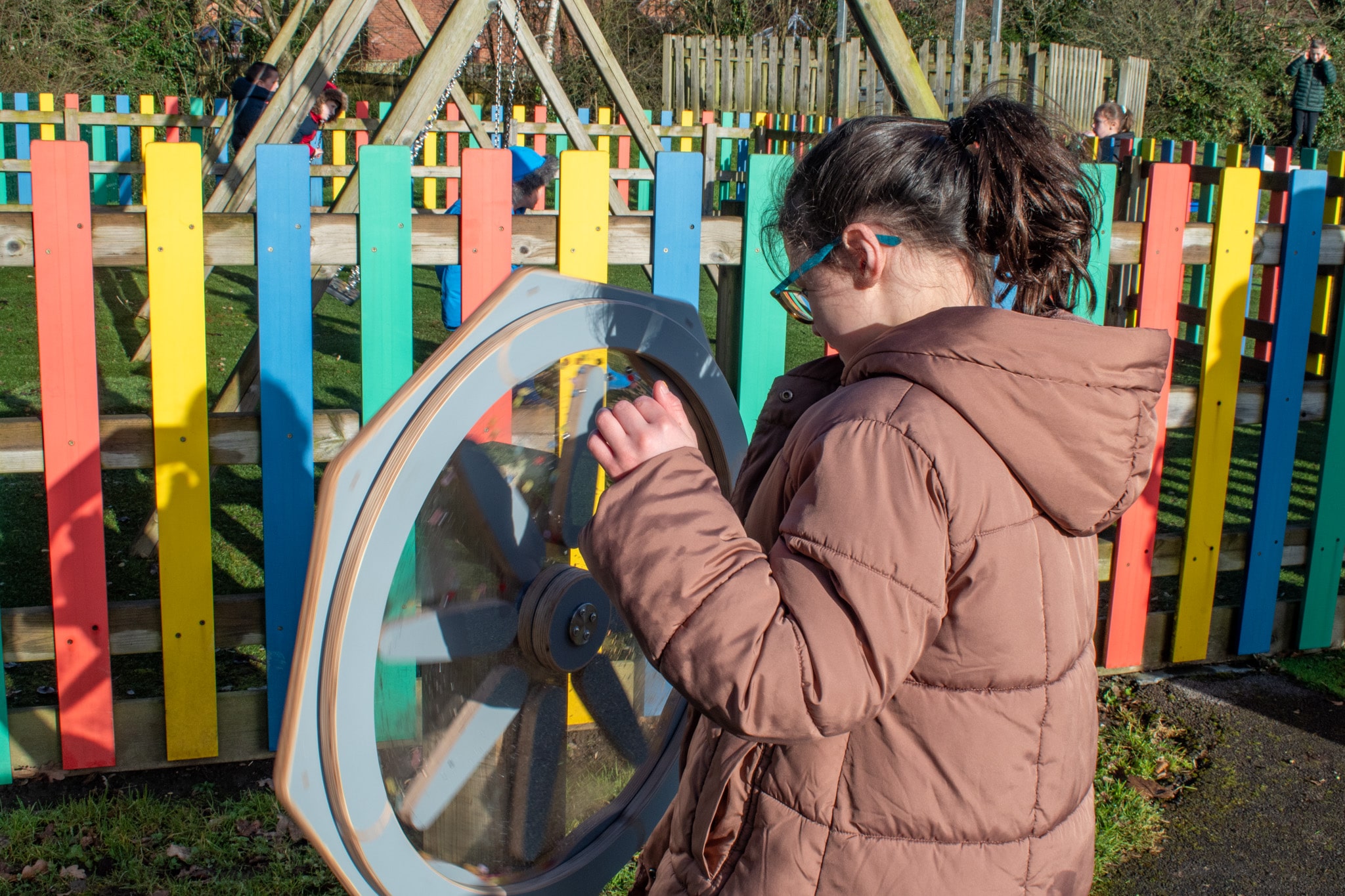 A little girl is standing close to the Sound Sensory Spinner as she spins it.