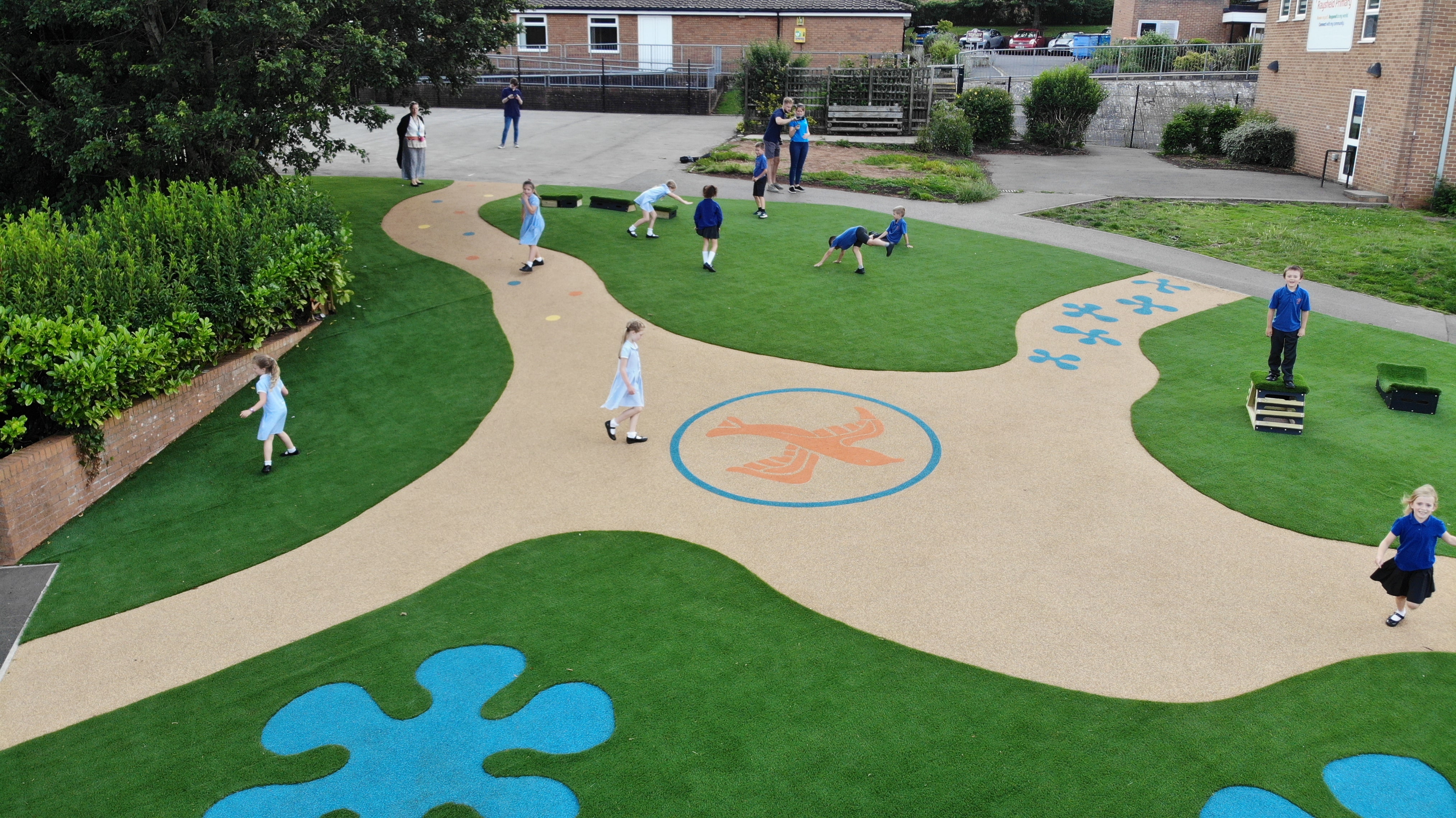 A playground that has been surfaced in wetpour and artificial grass, creating a lively look.