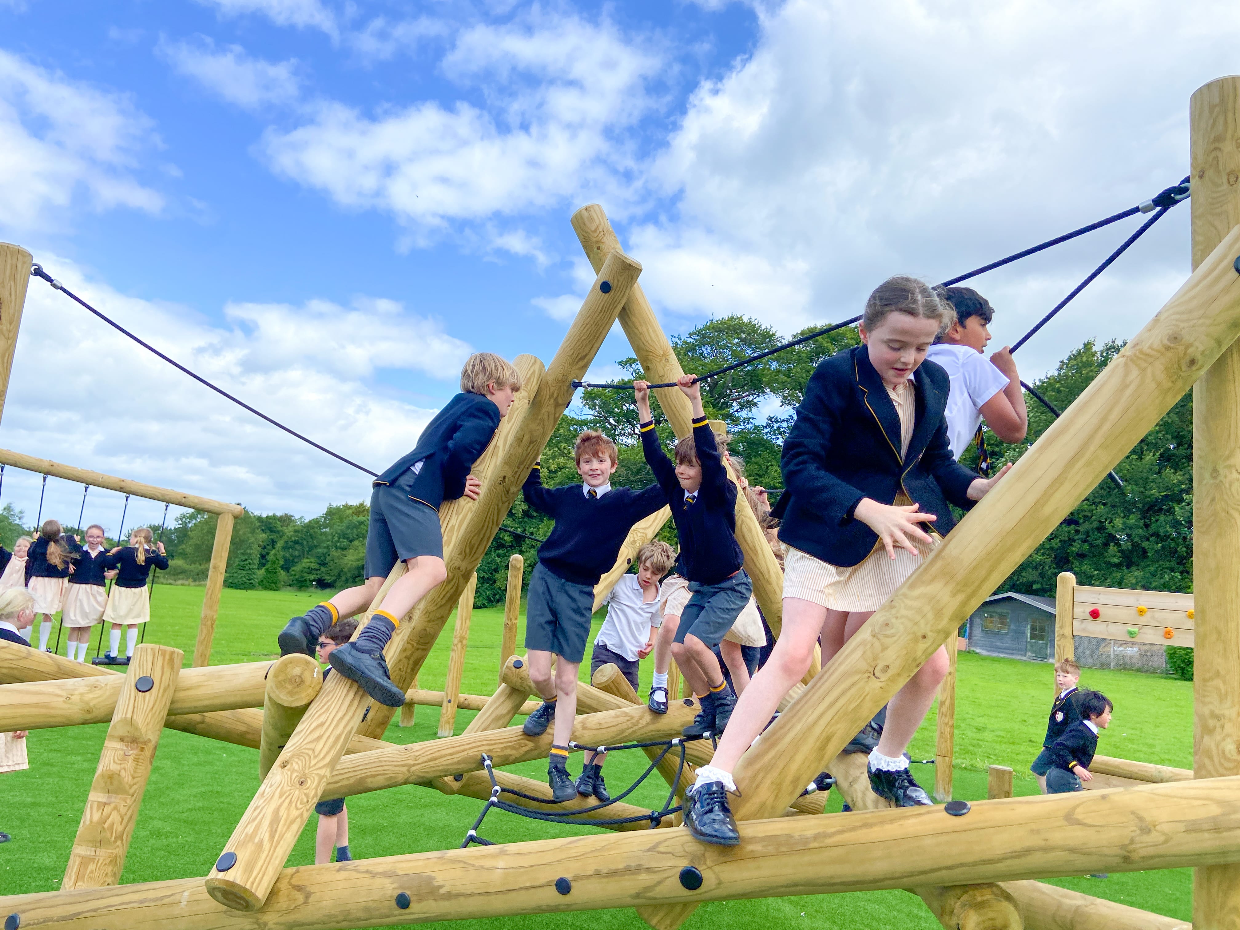 A group of children are climbing on the Bowfell Climber and exploring the structure.