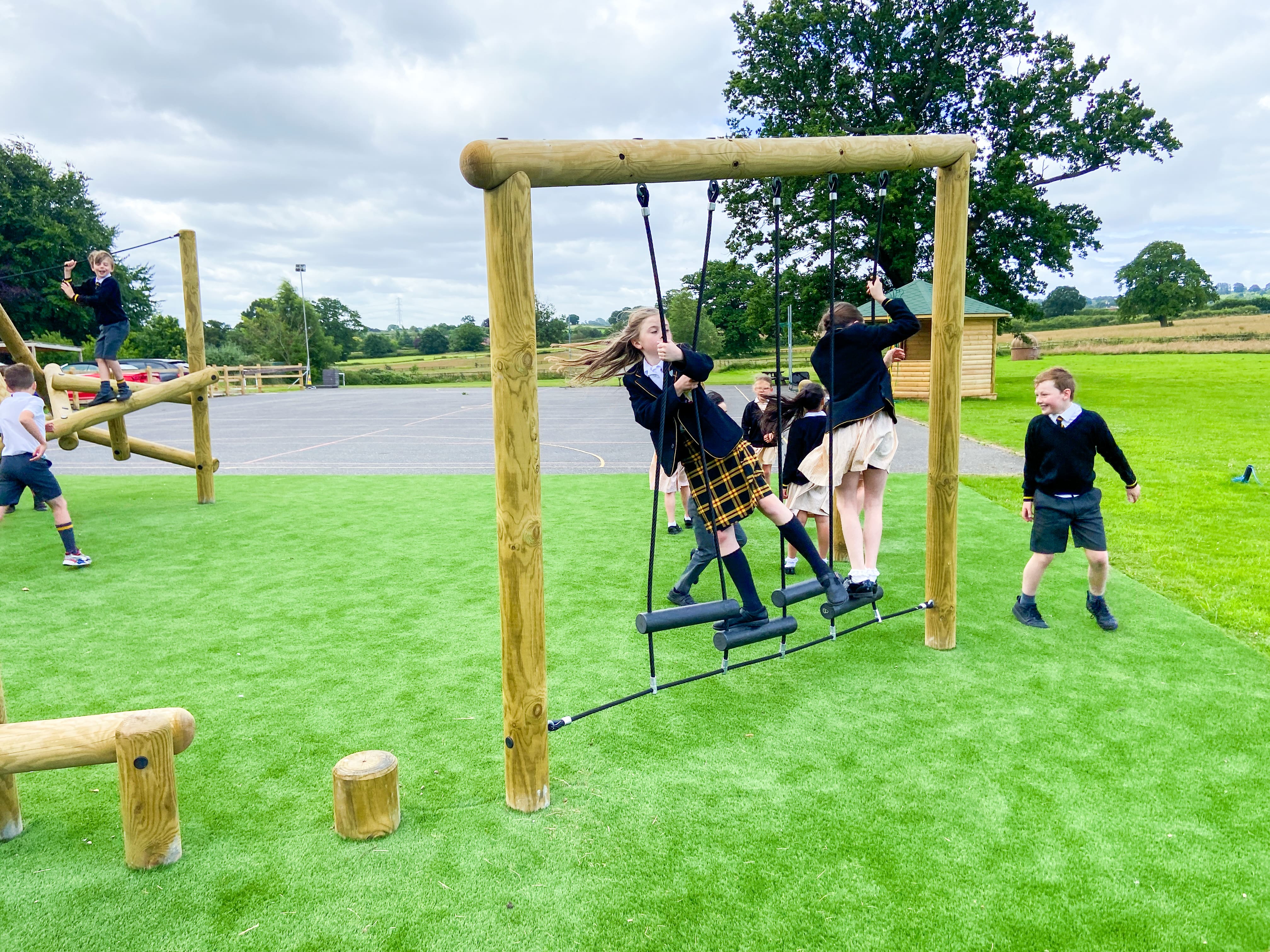 A small group children are crossing a Step Rung Traverse at a low level.