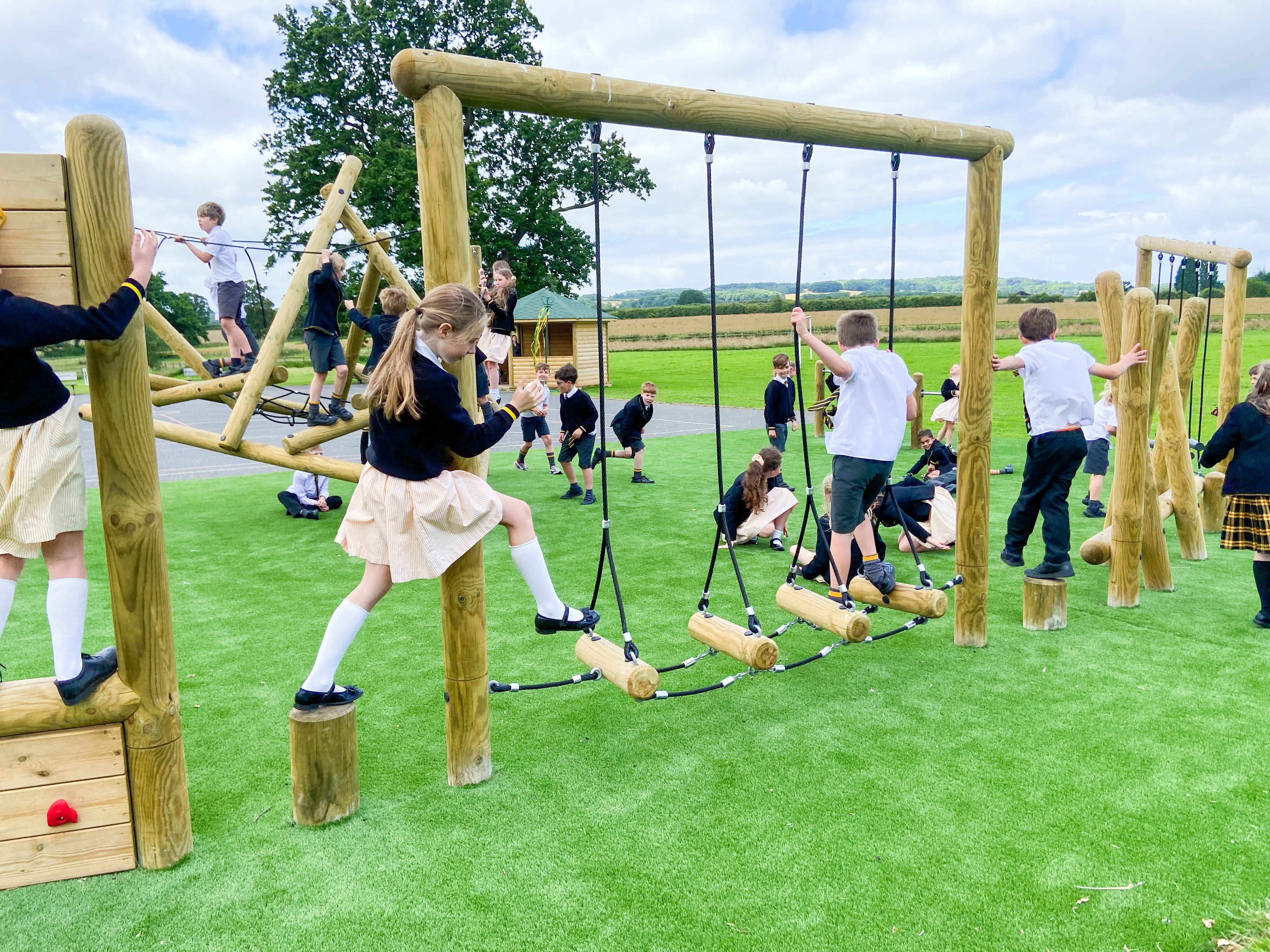 Children are crossing the Horizontal Swinging Log Crossing as they advance through the trim trail.