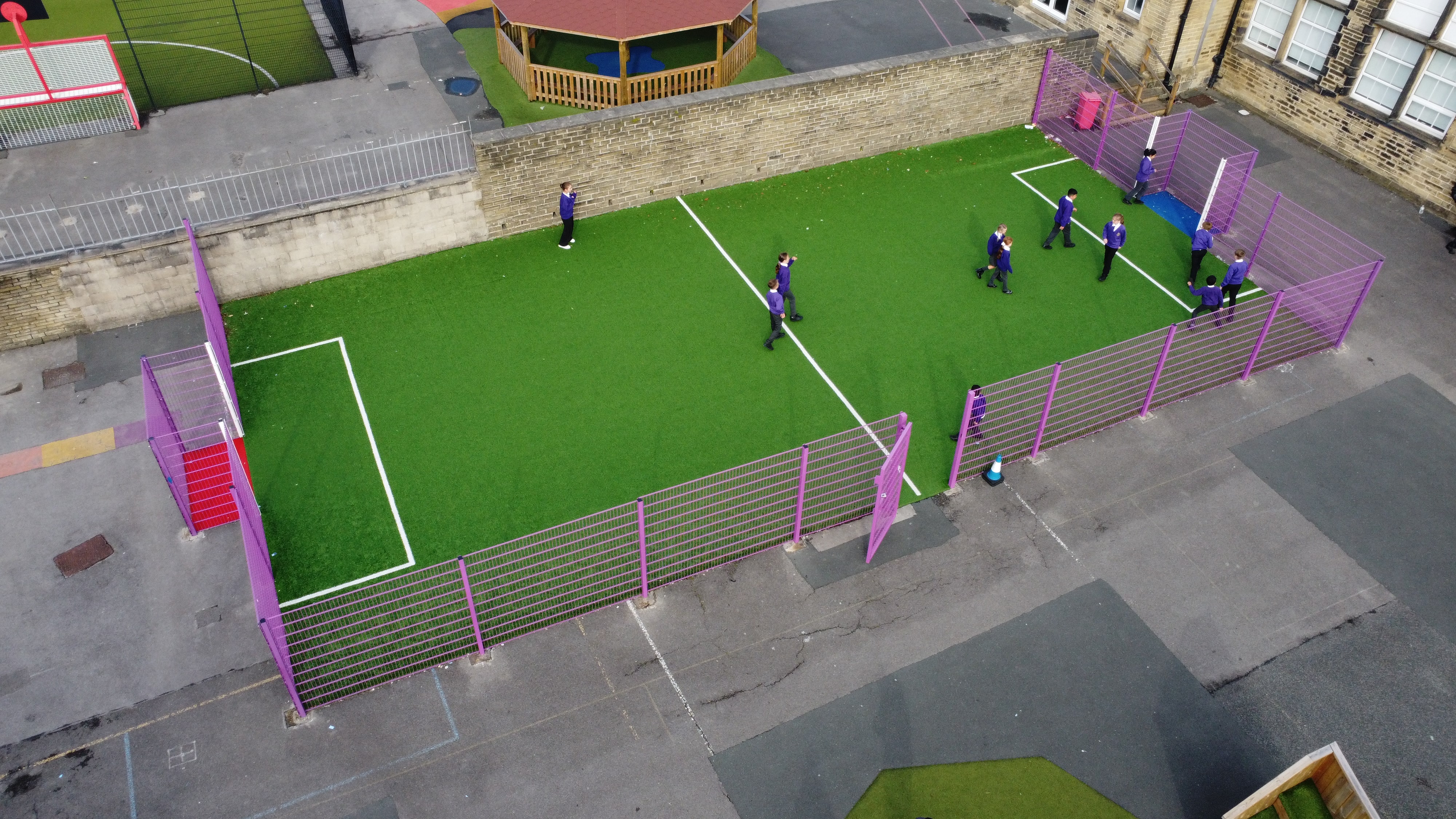 A 4g artificial grass MUGA that has purple fencing surrounding the pitch.