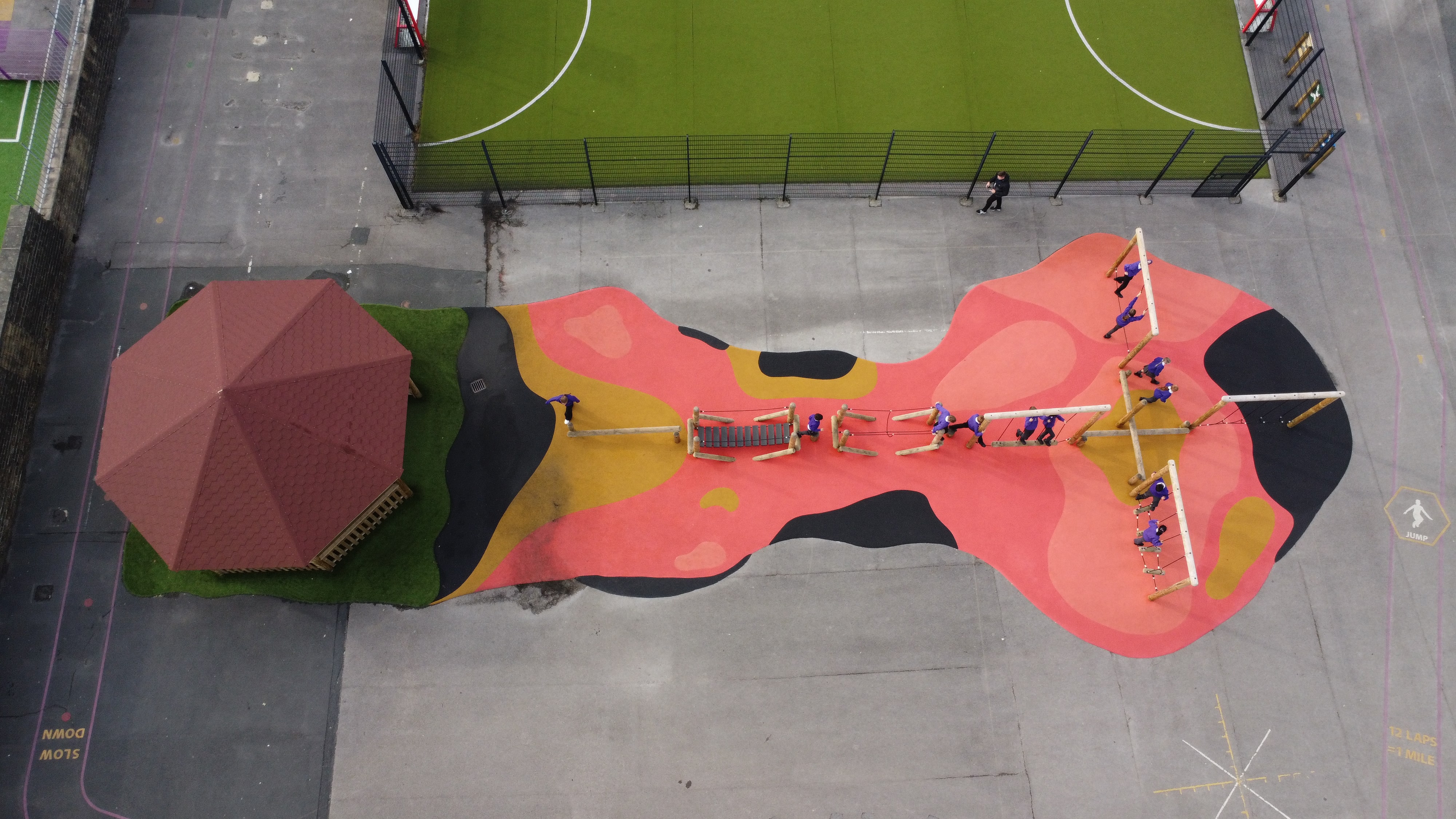 A birdseye view of the floor is lava wetpour design, showcasing the outdoor classroom and trim trail.