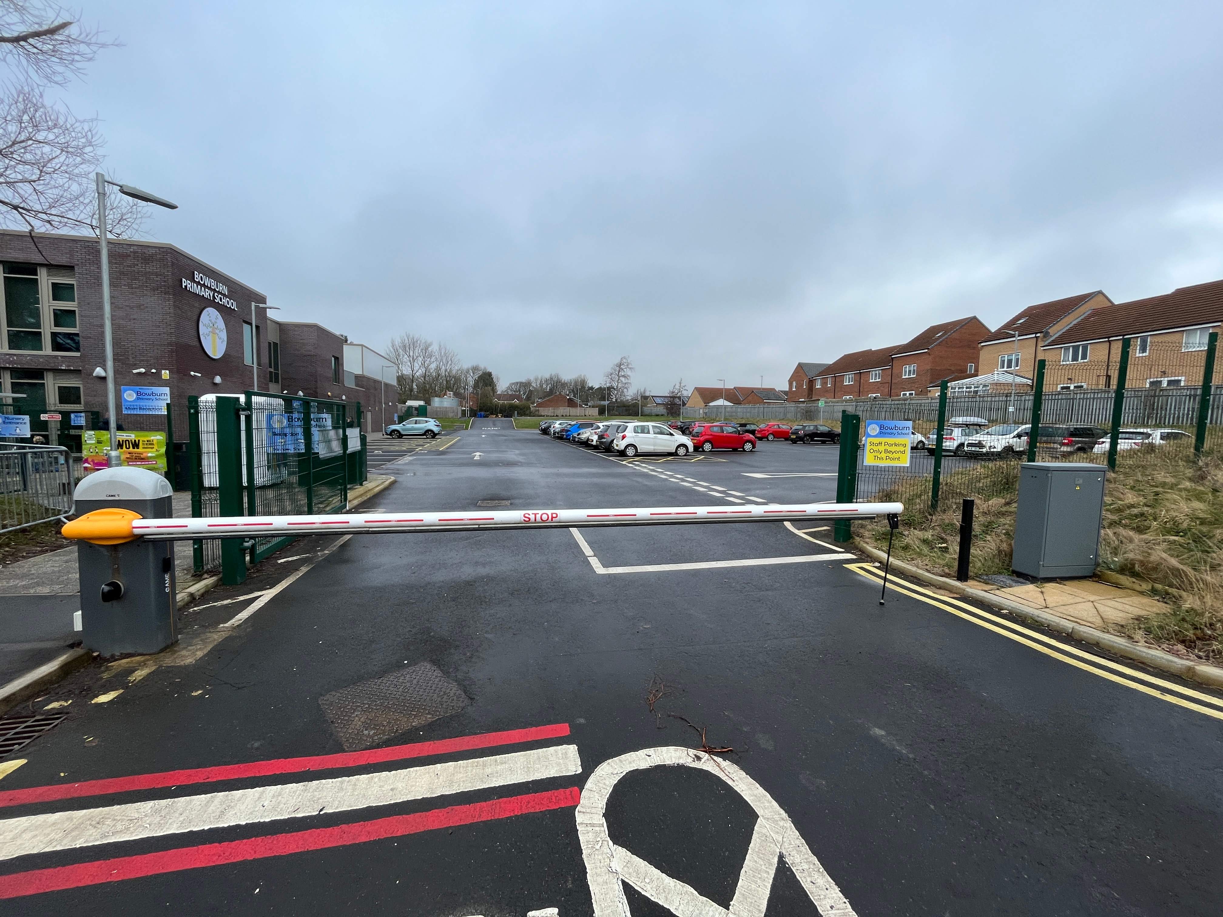 The entrance to Bowburn Primary School car park, with a boom barrier restricting access to the area.