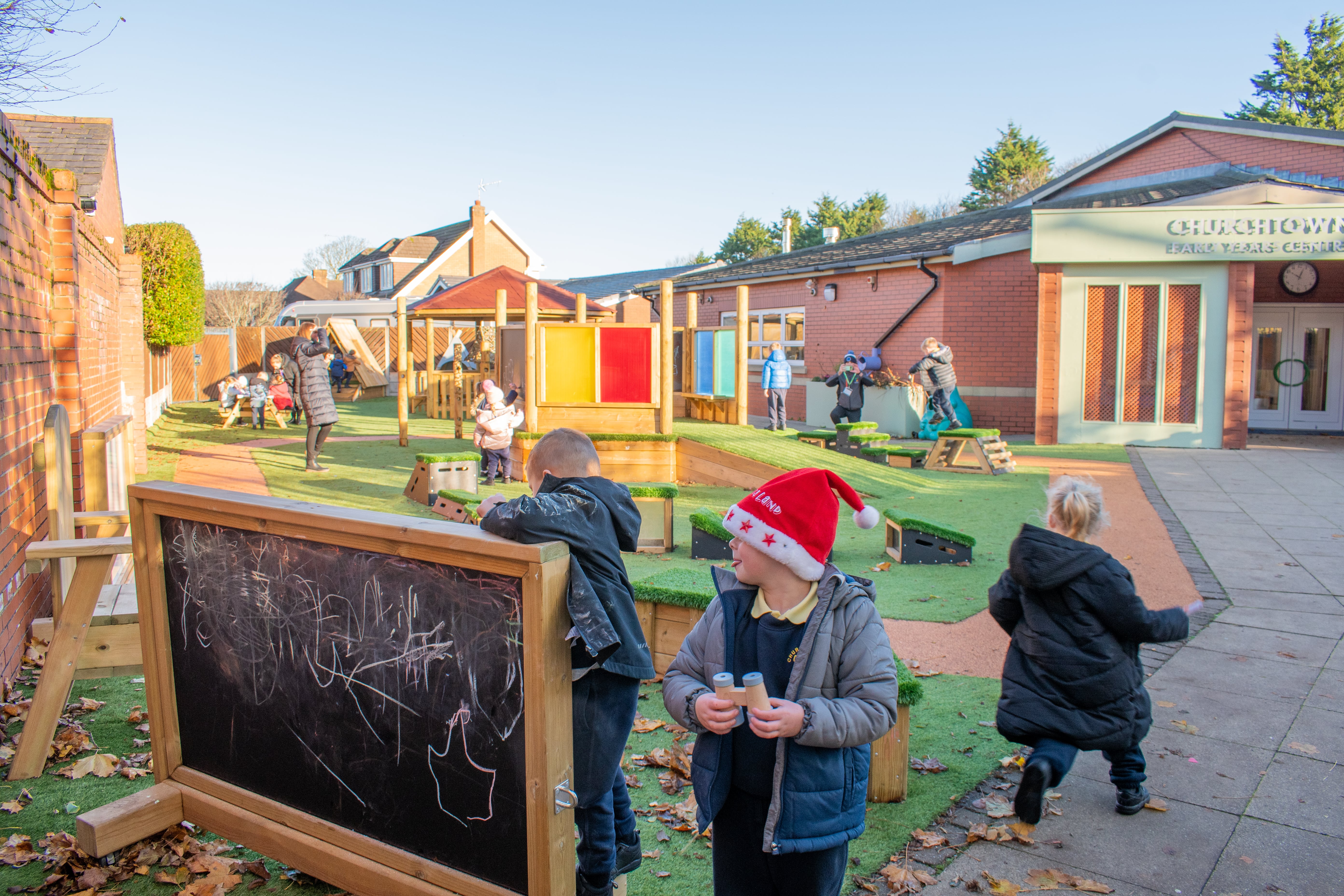 A small group of EYFS children are exploring their new playground, full of brand new equipment.