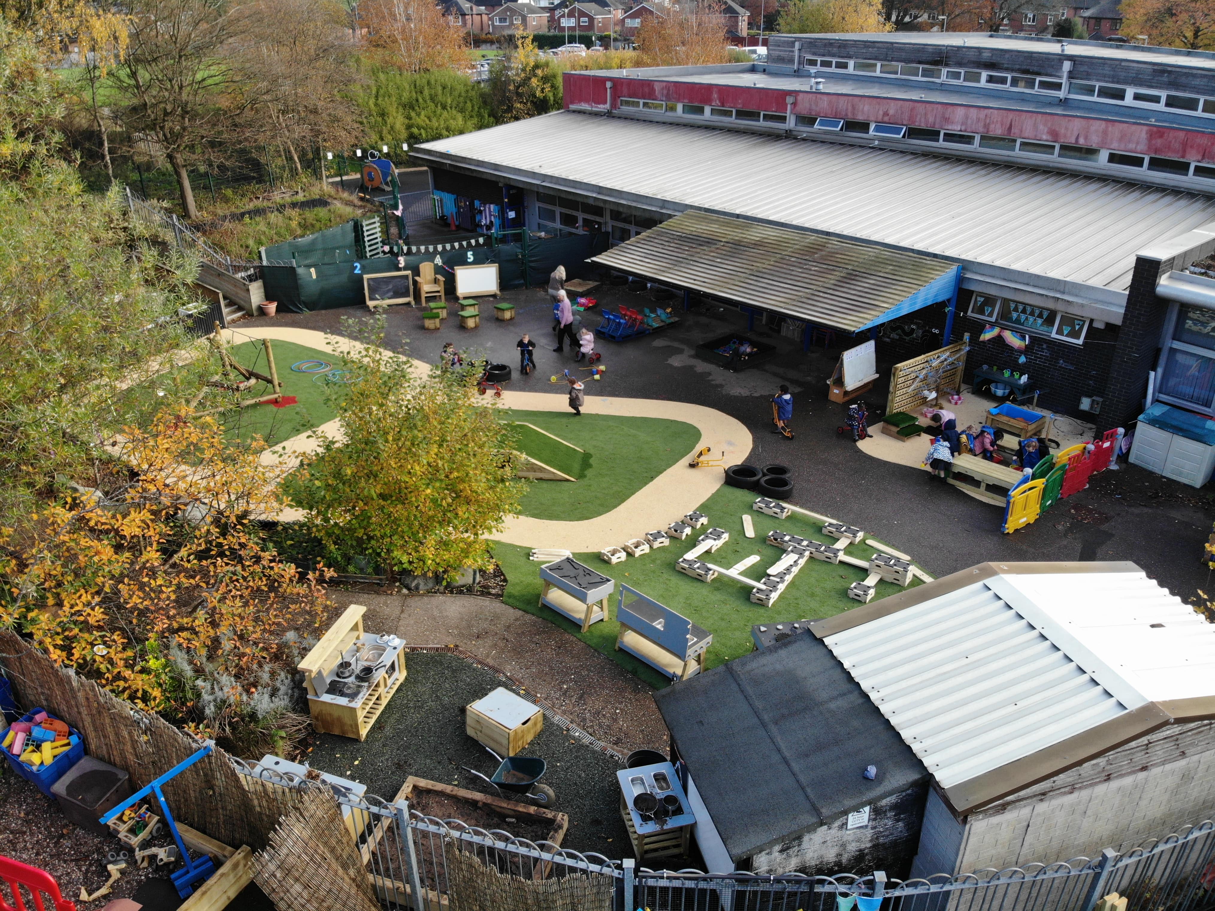 A selection of school playground equipment on a freshly laid artificial grass surface for the nursery.