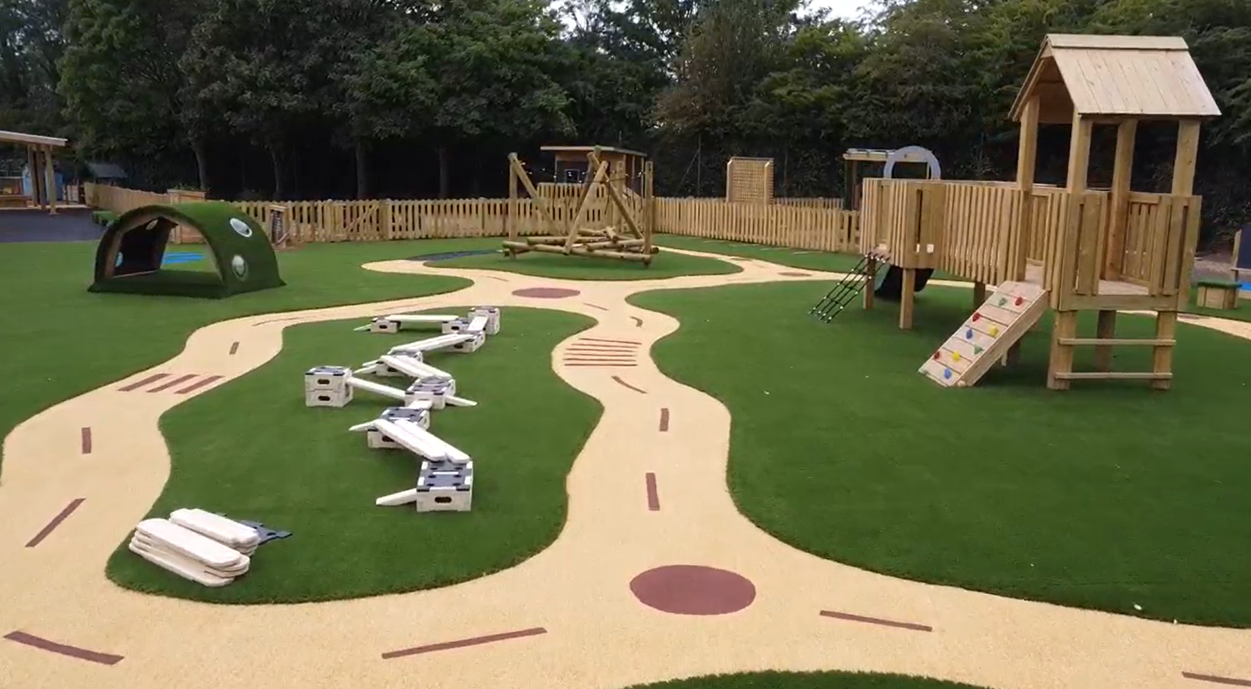 The centre of the new early years play area, with a variety of exciting and new active play equipment, on top of artificial grass and wetpour.