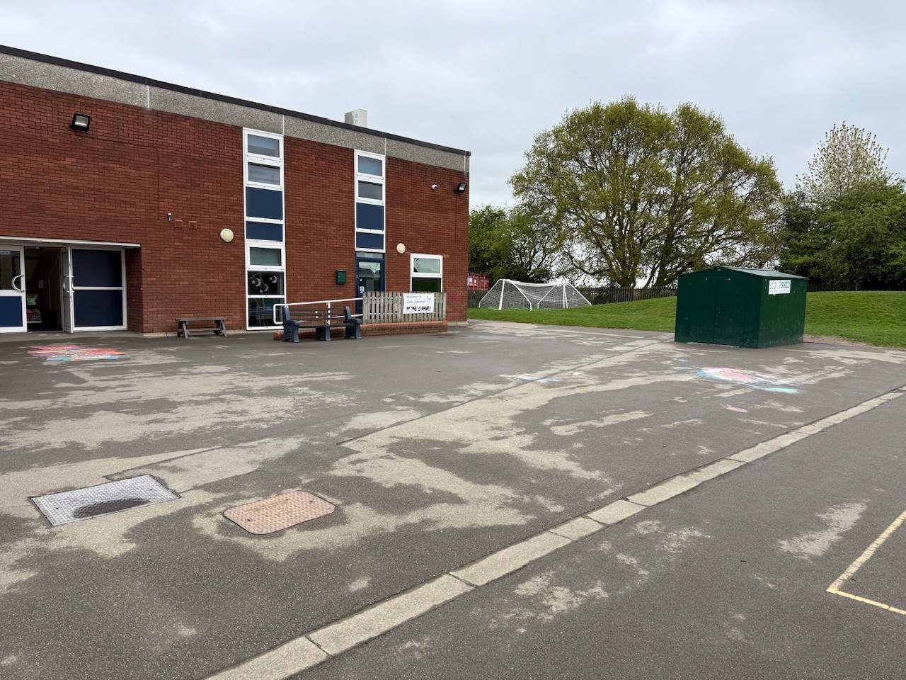An empty tarmac playground with no playground equipment.
