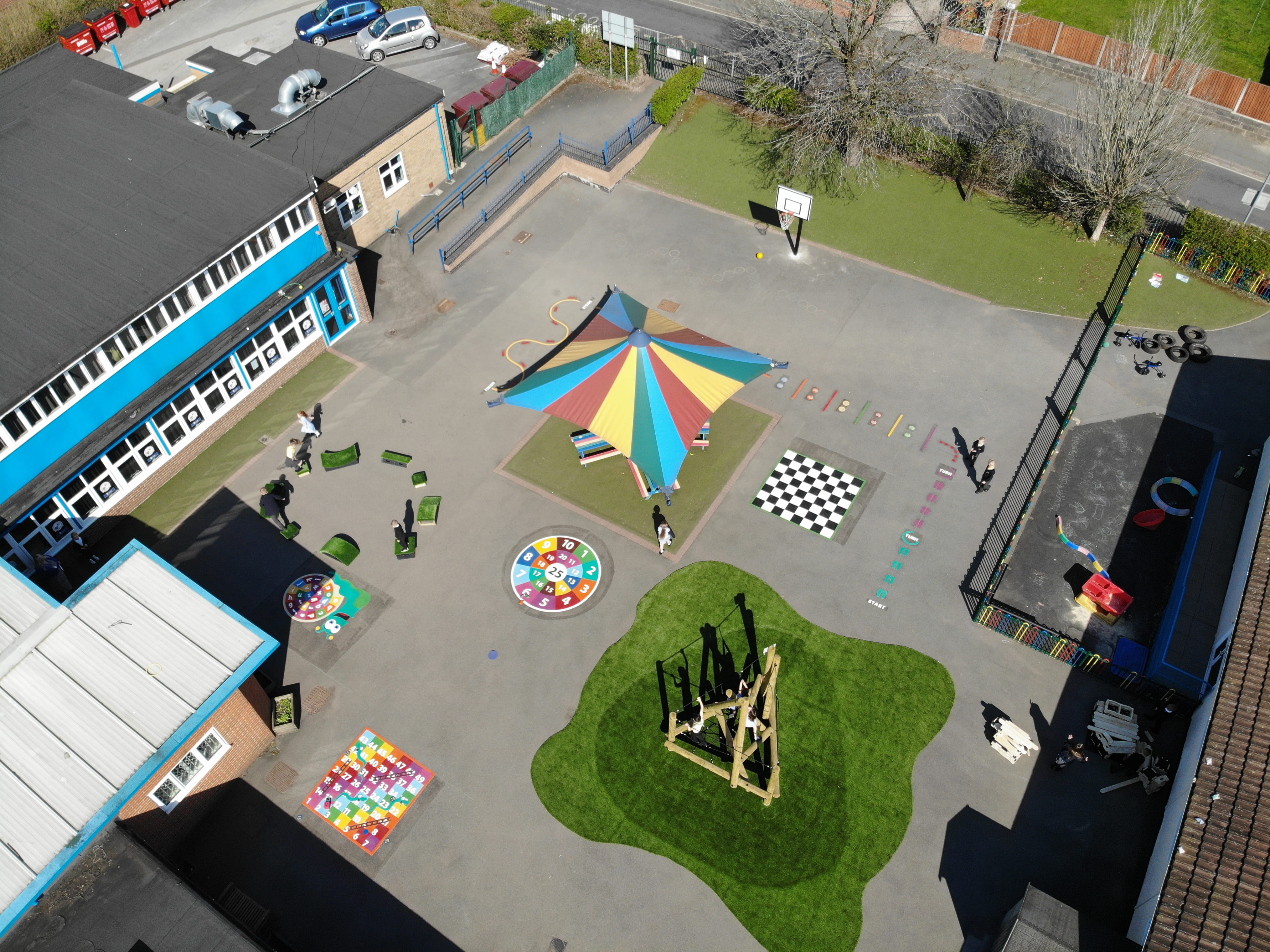 A birdseye view showcasing the entire new installation of the playground, showcasing the vibrant thermoplastic playground markings and equipment.